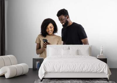 Portrait of a suspicious afro american couple with mobile phone isolated Wall mural